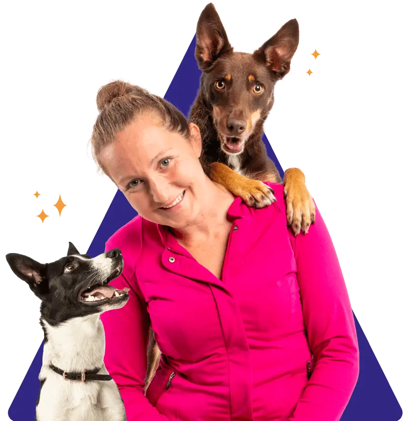 A person with a dog looking up at her and another dog behind her looking over her should. Both are focused dogs.